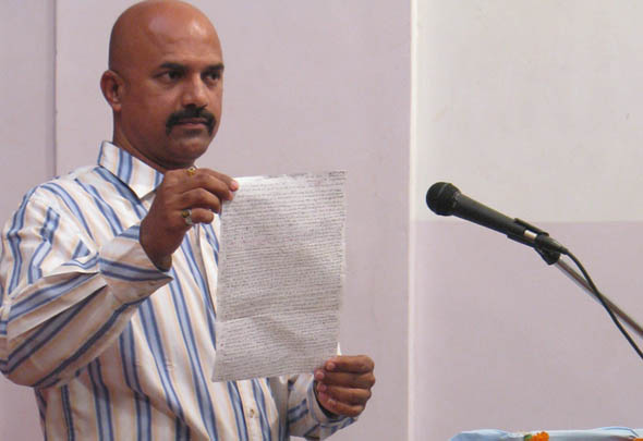 G. Rajesh Pednekar, poklonik Njegove Svetosti Dadajija pokazuje otvoreno pismo  s  predviđanjima.